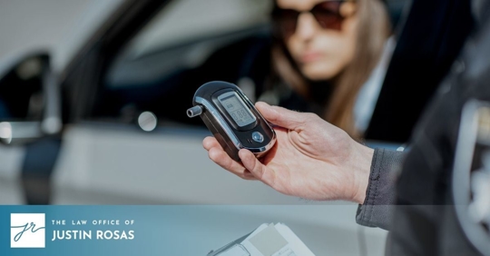 woman in car and police officer holding breathalyzer
